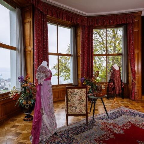 Blick auf einige Ausstellungsstücke, insbesondere historische Kleider in einem Raum auf Schloss Arenenberg